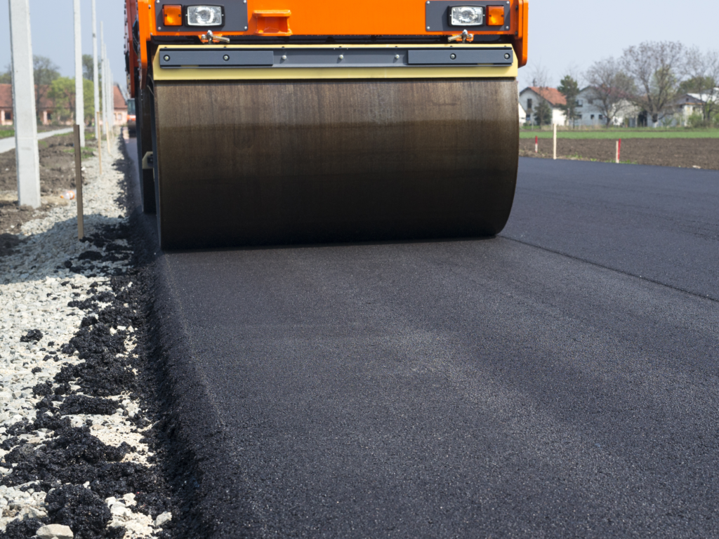 Straßenbauer fährt mit Walze.